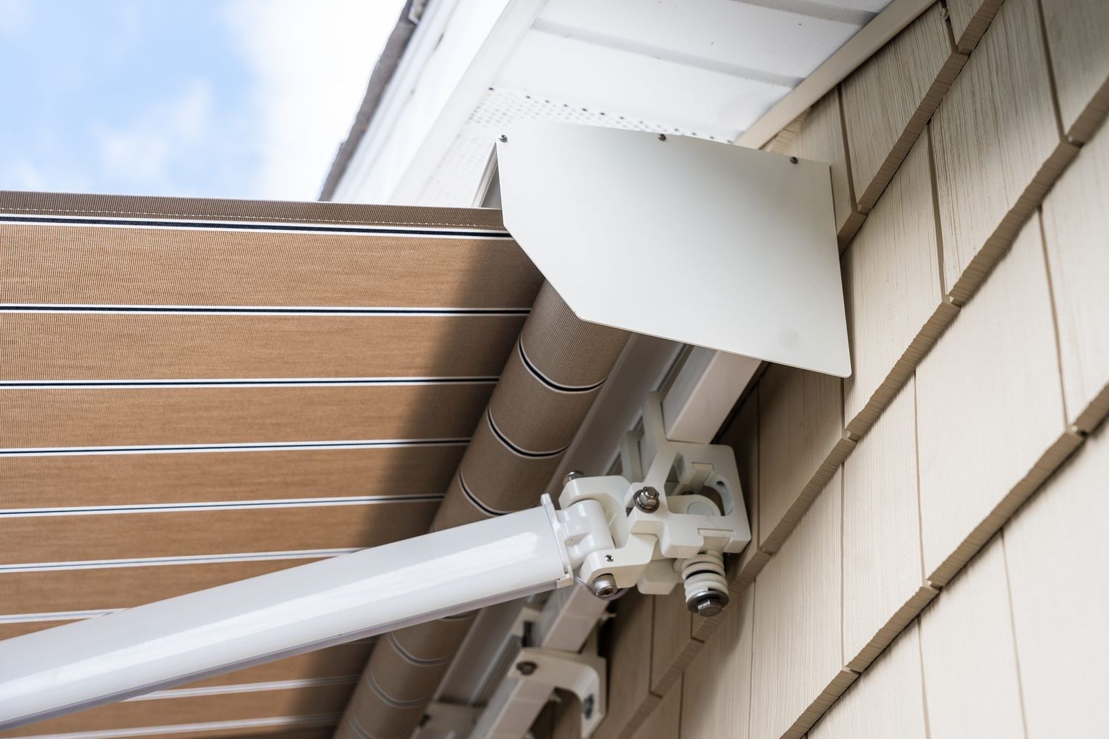 The roller tube and lateral-arm shoulder bracket of an awning, where a tubular motor is housed inside the tube