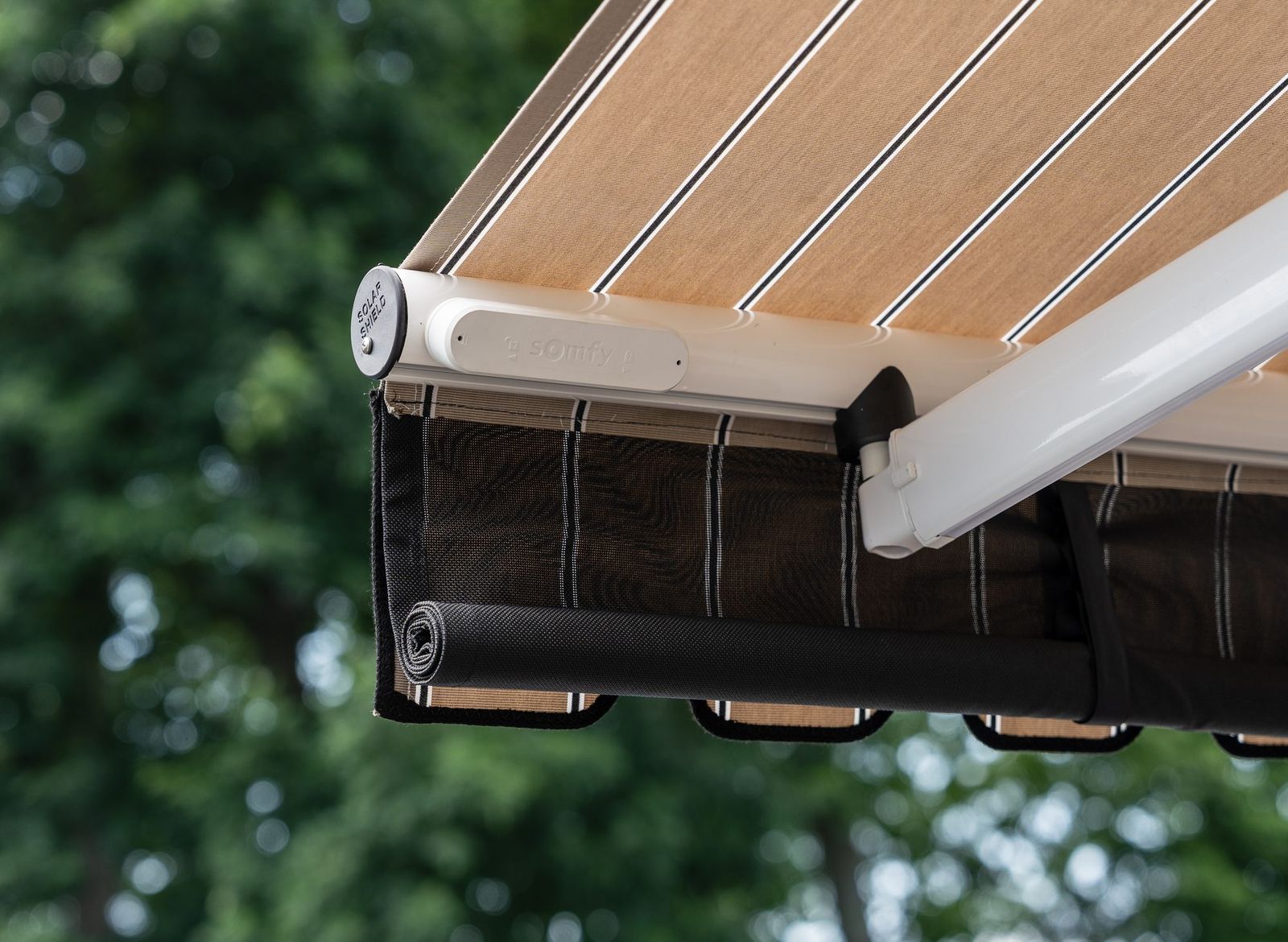 A Somfy wind sensor mounted on the front bar of an awning, where movement is detected